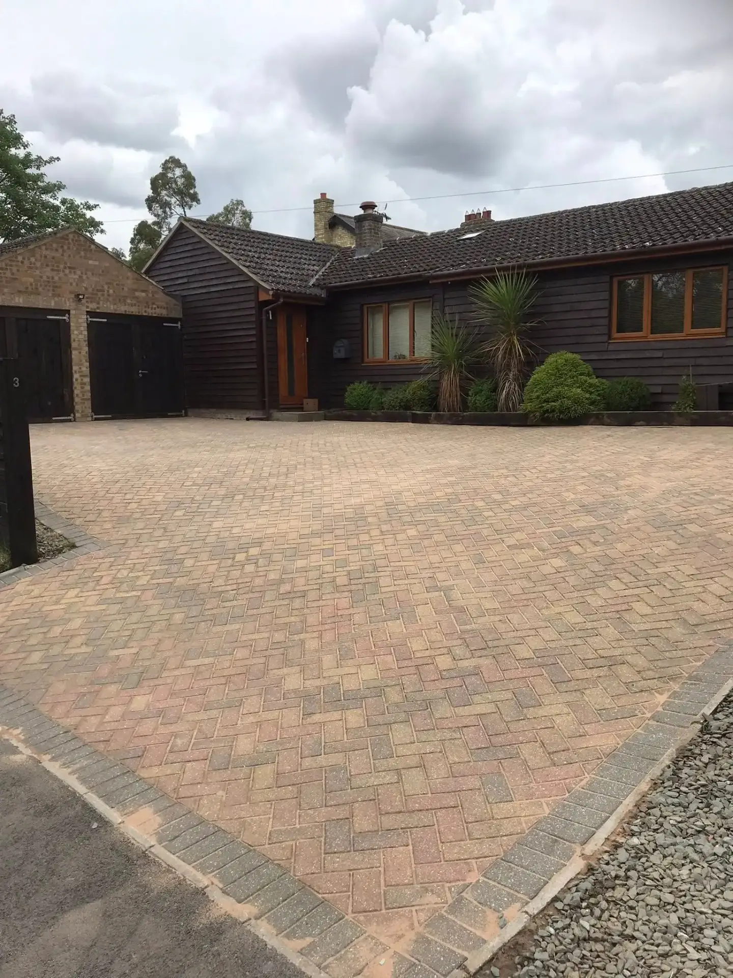 Large red and charcoal block paving driveways outside a detached house in Cambridgeshire.